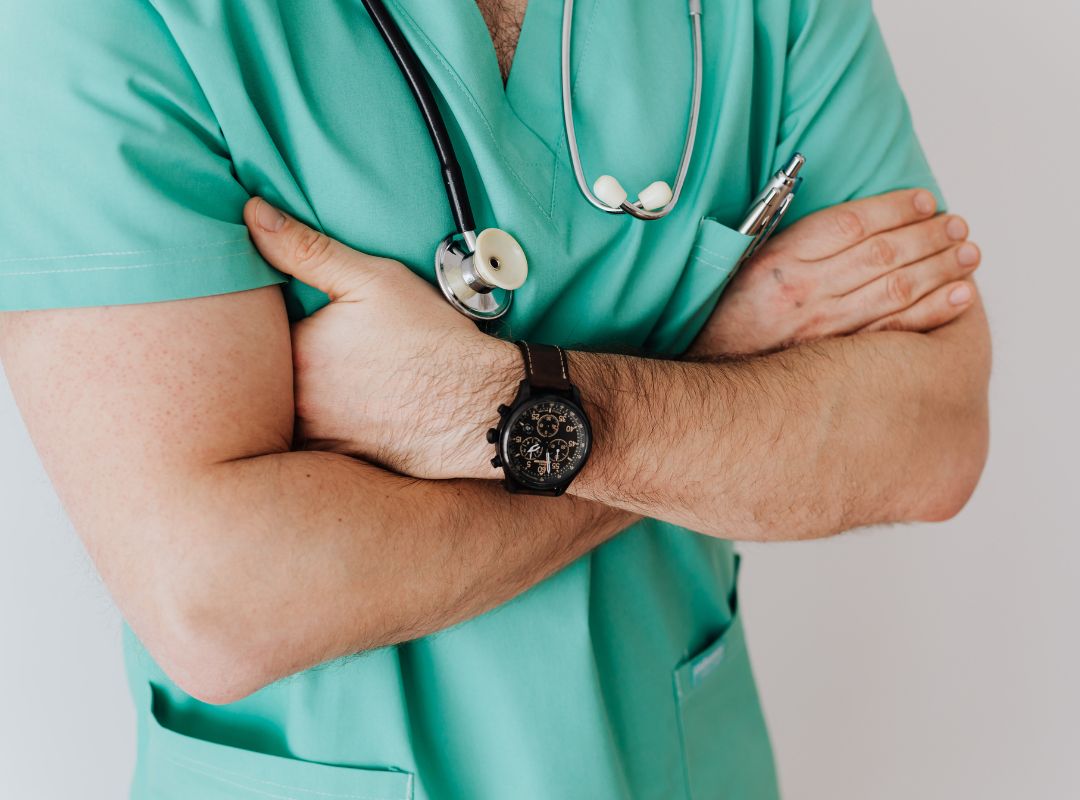 Personen mit verschränkten Armen die am rechten Arm eine Uhr trägt. Uhrenarmband pflegen.